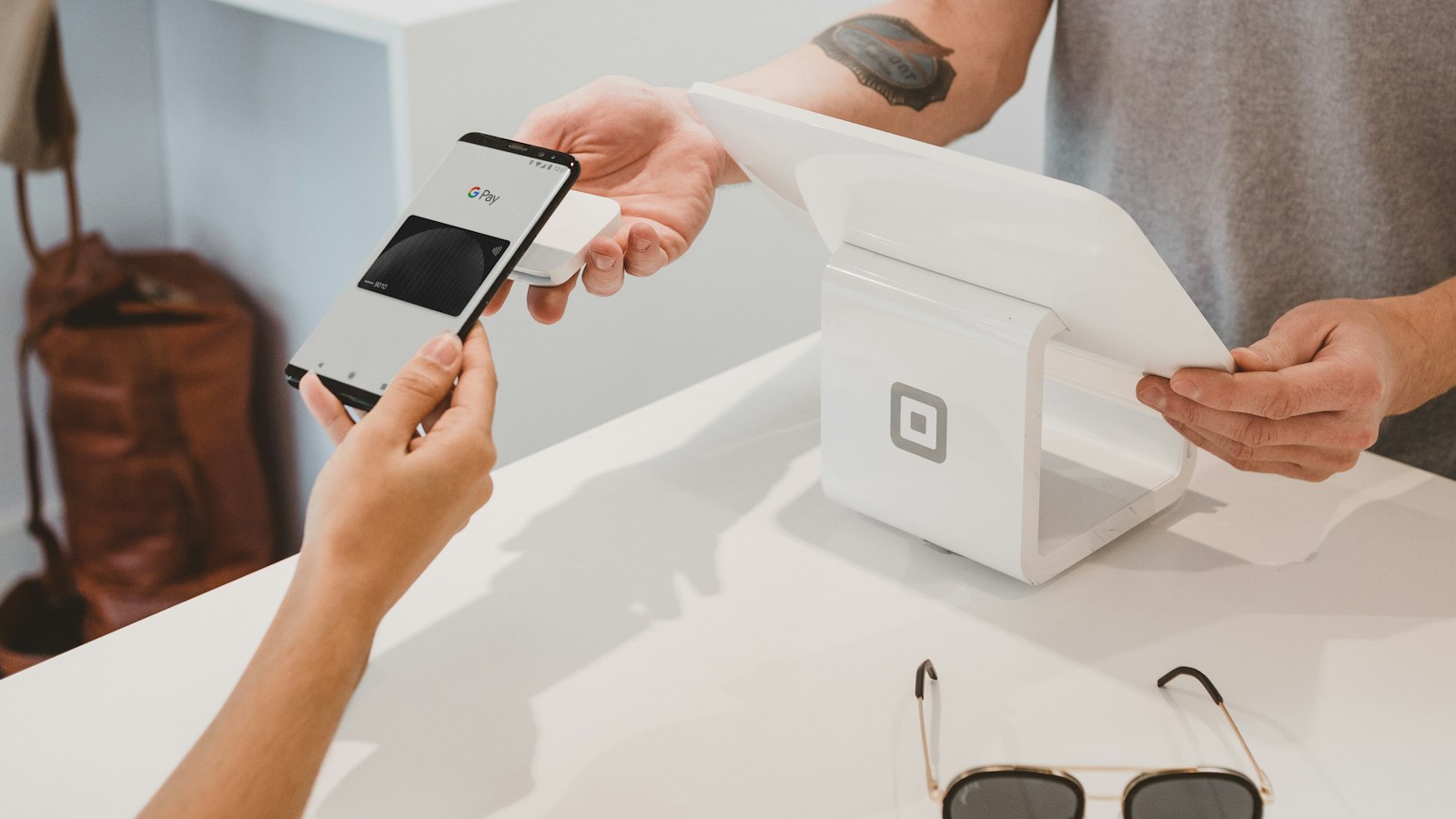 Customer tapping Google Pay on a phone at a tablet checkout — Shopify checkout after Checkout Extensibility